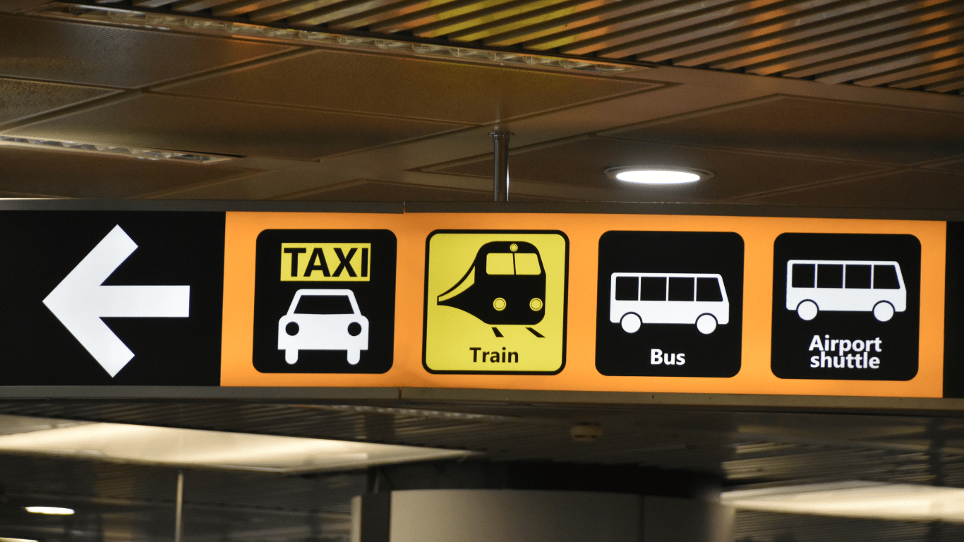 Sign showing different modes of transportation, including buses, trains, and taxis.