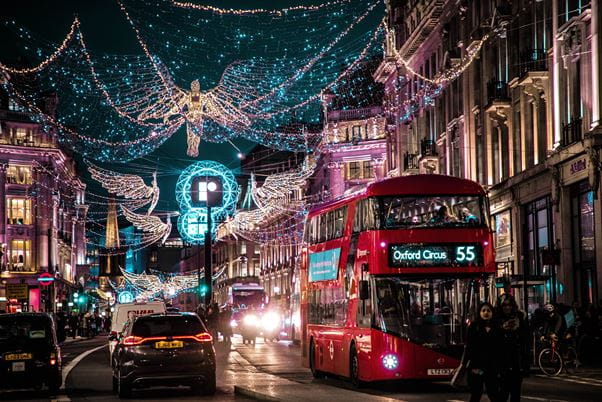 London street at Christmas time with red bus and decorations