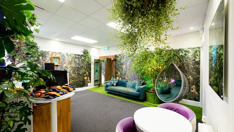 Seating area with egg shaped swing chair, plush sofa and refreshments with a tropical design