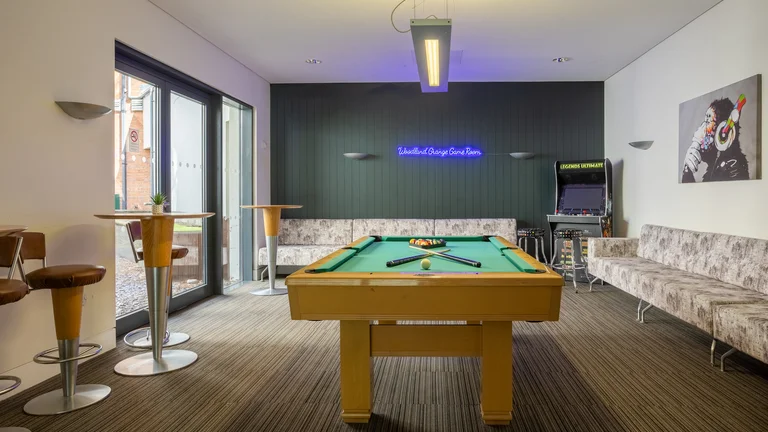 Games room with pool table, arcade game, seating area, and neon sign on  wall that reads Woodland Grange Games Room 