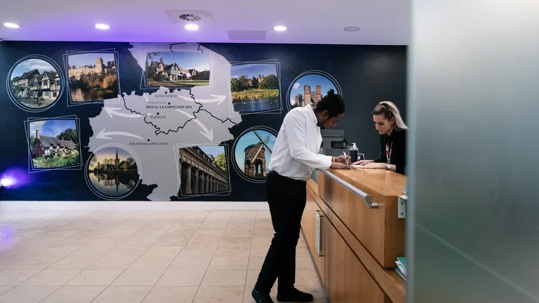 Reception at Woodland Grange. Image of a map of Leamington Spa and images of tourist attractions on the far wall 