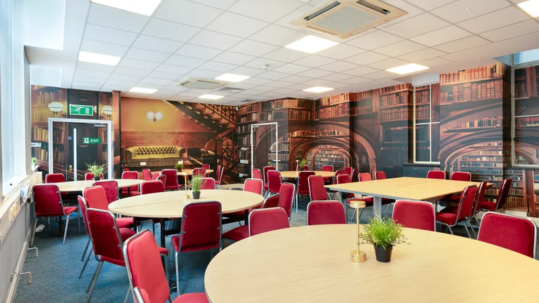 Seating lounge with tables and chairs, library with print on the walls