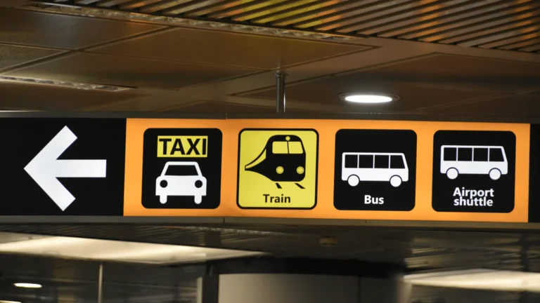 Sign showing different modes of transportation, including buses, trains, and taxis.